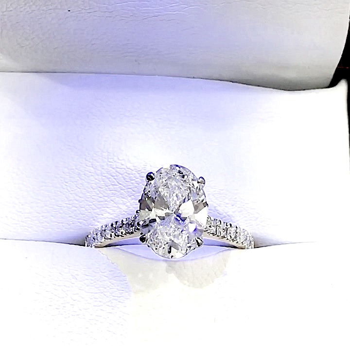 18kt White Gold Engagement Ring with 2.5 carat lab diamond at the center (Color: E | Clarity: VS1 | Oval Cut) and natural E / VVS grade Setting Diamonds. Cathedral Setting with Hidden Halo.